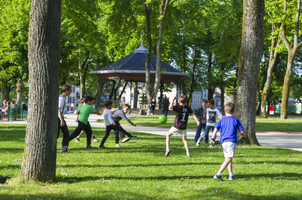des enfants qui jouent dans un parc à Chaumont. En arrière-plan, un kiosque.