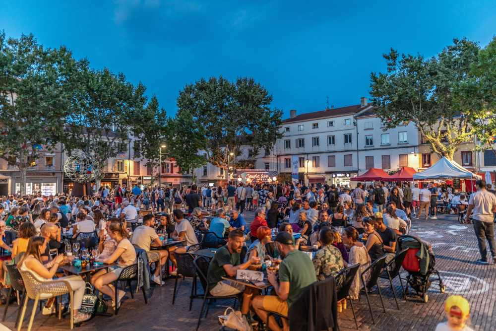 Les terrasses de la place du marché à Roanne pleines de monde en début de soirée, l'été.